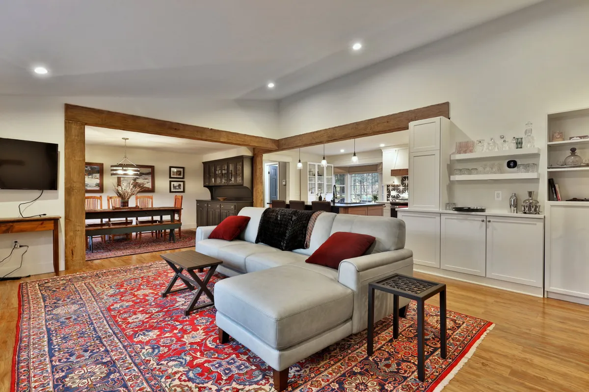 The photo displays a comfortable living and dining space with a sofa, rug, dining area, and TV. The arrangement is ideal for relaxing after a day out, hosting family gatherings, watching movies, or enjoying shared meals.